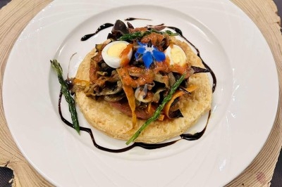 Traiteur Traiteur Lallemand Montblanc #3 Tartelette garnie de légumes grillés, œufs de caille, asperges et sauce balsamique, servie sur une assiette blanche.