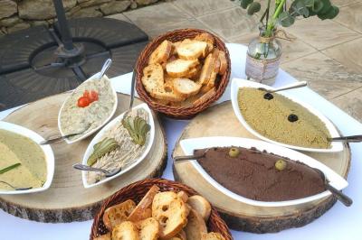 Assortiment de tartinades et de pain disposés sur des plateaux en bois, avec une décoration florale en arrière-plan.