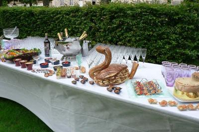 Traiteur Eclat des Saveurs Marles-en-Brie #4 Table dressée en extérieur avec verres, bouteilles, pains, amuse-bouches et desserts sur une nappe blanche.