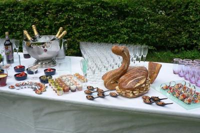 Traiteur Eclat des Saveurs Marles-en-Brie #5 Table dressée avec des coupes de champagne, amuse-bouches variés et pain en forme de cygne, en extérieur.
