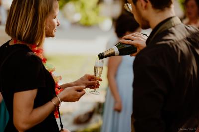 Traiteur Au Bois du Bon Sejour Aubeterre #4 Une personne verse du champagne dans le verre d'une femme lors d'un événement en extérieur.