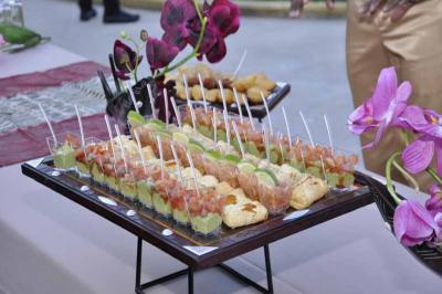 Plateau de verrines et amuse-bouches variés disposés sur une table décorée avec des fleurs violettes.
