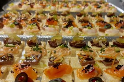 Traiteur Crazy Cook Catering Gottesheim #4 Plateau de canapés variés garnis de saumon, crevettes, olives et herbes, disposés en rangées sur une table.