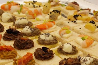 Traiteur Crazy Cook Catering Gottesheim #5 Plateau de canapés variés avec garnitures comme crevettes, tapenade, fromage et légumes sur pain blanc.