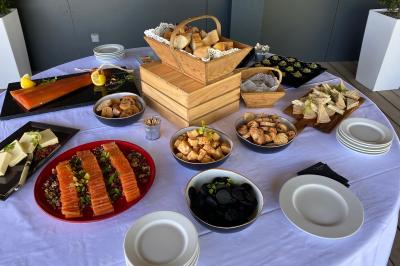 Traiteur Vironneau Evénementiel Galgon #2 Buffet avec saumon fumé, fromages, pains, verrines et divers amuse-bouches disposés sur une table blanche.