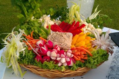 Traiteur Borges Evenements Draguignan #5 Plateau de crudités colorées avec radis, carottes, poivrons, chou-fleur et trempette au centre, présenté sur un lit de…