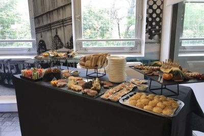 Traiteur Lapierre Traiteur Saint-Denis #3 Buffet varié avec pains, amuse-bouches, fruits et desserts, disposé sur une table dans une salle lumineuse.