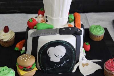 Traiteur Le Maydane Avs Clamart #4 Gâteau décoré en forme de toque et tablier de chef, entouré de légumes, cupcakes et accessoires culinaires.