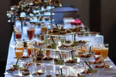 Traiteur Le Maydane Avs Clamart #3 Buffet avec verrines, mini-sandwichs et jus de fruits disposés sur des présentoirs en verre et métal.