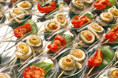 Traiteur Him Traiteur Sartrouville #1 Assortiment de bouchées apéritives avec anchois, olives, tomates séchées et feuilles de basilic sur des cuillères…