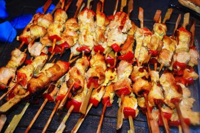 Traiteur Him Traiteur Sartrouville #5 Brochettes de viande grillées avec morceaux de poivrons rouges, disposées sur un plateau.
