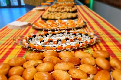 Plateau de buffet avec divers amuse-bouches, petits pains et brochettes, disposés sur une nappe colorée.