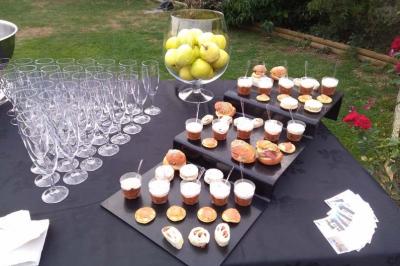Traiteur Spirale Gourmande Unverre #1 Table dressée avec des verrines, amuse-bouches, verres vides et un grand vase rempli de pommes vertes, en extérieur.
