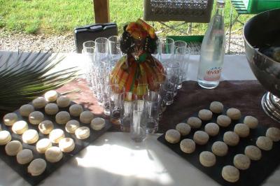 Traiteur Spirale Gourmande Unverre #2 Plateau de macarons disposés autour de verres vides, d'une bouteille d'eau et d'une décoration colorée sur une table.