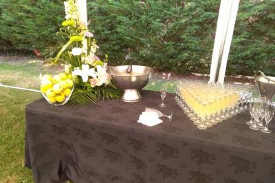 Traiteur Spirale Gourmande Unverre #5 Table dressée avec une nappe noire, contenant une vasque, des verres alignés, un vase de citrons et une composition florale.