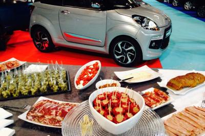 Traiteur Traiteur Calabria - Le Domus Martigues #2 Buffet varié avec charcuterie, tapas et viennoiseries en premier plan, petite voiture grise exposée en arrière-plan.