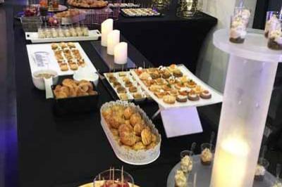 Traiteur Traiteur Calabria - Le Domus Martigues #5 Buffet de desserts variés avec verrines, pâtisseries et bougies décoratives dans une salle de réception élégante.