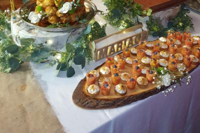Traiteur Marc et Sophie Traiteur Cuisine & Services Limas #5 Buffet de desserts avec verrines colorées, pièce montée et décoration florale sur une table de mariage.