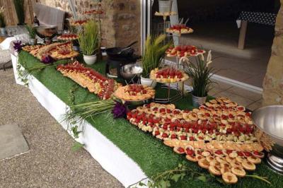 Traiteur Au Faim Délice Pont-Salomon #1 Buffet en extérieur avec une variété de plats et amuse-bouches disposés sur une table recouverte de gazon artificiel.