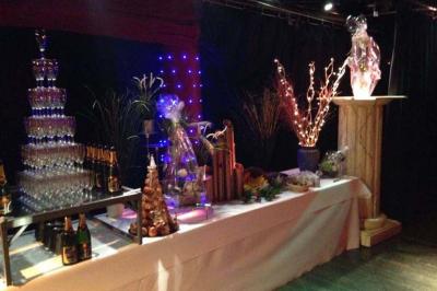 Traiteur Au Faim Délice Pont-Salomon #3 Table décorée pour un événement avec pyramide de verres, bouteilles de champagne et sculptures lumineuses.