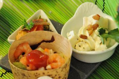 Traiteur Aux Delices de Loire Saint-Denis-de-l'Hôtel #5 Assortiment de verrines et amuse-bouches avec crevettes, légumes et fromage, présenté sur un fond vert.