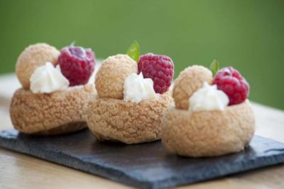Traiteur Frederic Fouquet Créateur d'Emotions Culinaires Faverges #4 Choux garnis de crème, décorés de framboises et feuilles vertes, présentés sur une ardoise noire.