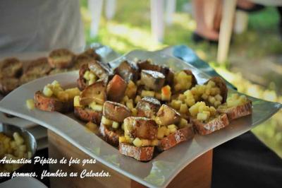 Tranches de foie gras sur pain grillé, garnies de dés de pommes flambées au Calvados, présentées sur un plateau.