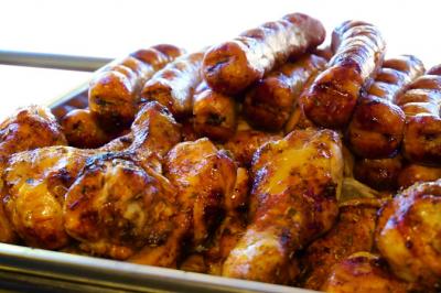 Traiteur La Cocotte Mobile Champigny-sur-Marne #5 Poulet rôti et saucisses grillées disposés dans un plat en métal.