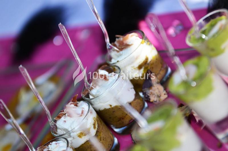 Verrines garnies de mousse, crème et légumes, présentées avec des cuillères sur une nappe rose.