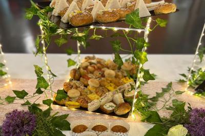 Traiteur L'instant Gourmand Beauchamp #5 Plateau de buffet garni de sandwichs, roulés, muffins et autres amuse-bouches, décoré de guirlandes lumineuses et de…