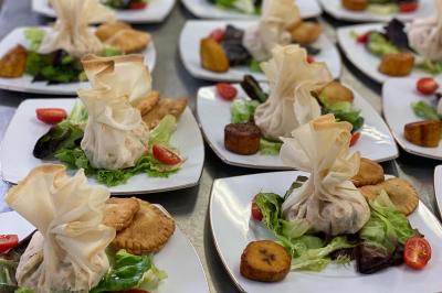 Assiettes garnies de salades, aumônières en pâte, tomates cerises et accompagnements variés.