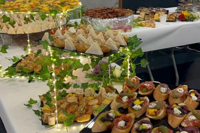 Traiteur L'instant Gourmand Beauchamp #3 Plateaux de canapés variés et décorés, disposés sur des présentoirs ornés de guirlandes lumineuses et de feuillage.