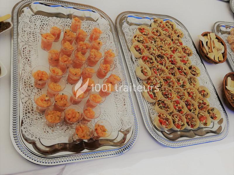 Traiteur Lou Pignatoun Grasse #1 Plateaux de verrines de crevettes et bouchées garnies de légumes colorés, disposés sur des nappes blanches.
