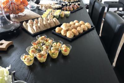 Buffet avec verrines, mini-burgers, sandwichs et desserts disposés sur une table noire.