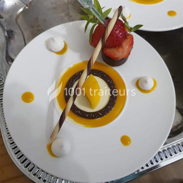 Traiteur Karine Roger Traiteur Fessanvilliers-Mattanvilliers #1 Assiette de dessert composée d'une mousse, d'un coulis de mangue, d'une fraise et d'une décoration en chocolat.