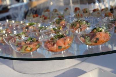 Traiteur Le Carré d'Or Traiteur Paris 15 #5 Coupes transparentes contenant des portions de tartare de saumon avec herbes fraîches, présentées sur un plateau en verre.
