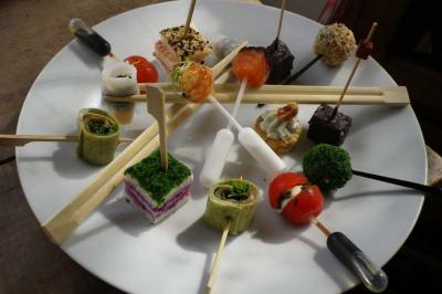 Traiteur Karen Réceptions Organisation Magny-en-Vexin #1 Assortiment de bouchées apéritives variées présentées sur un plateau rond avec des brochettes et pipettes.