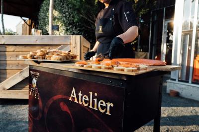 Traiteur Niel Traiteur Le Lion-d'Angers #5 Personne préparant des toasts au saumon fumé sur un stand en extérieur, avec des planches en bois et un décor naturel.