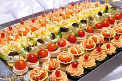 Traiteur Vb Traiteur Gradignan #2 Plateau de canapés variés avec légumes, fromages, saumon et décorations colorées, disposés sur une table.