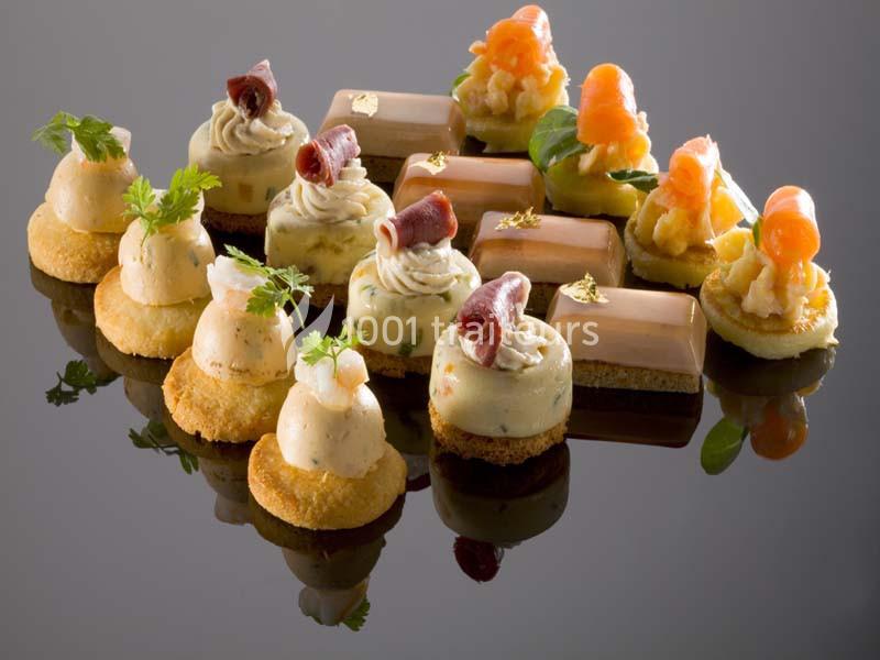 canapés Assortiment de bouchées salées élégamment présentées sur une surface réfléchissante.