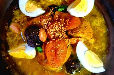 Traiteur Traiteur Sable d'Orient Rumilly #3 Plat de tajine avec des morceaux d'abricots secs, pruneaux, amandes, œufs durs et graines de sésame dans une sauce.