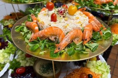 Plateaux de présentation garnis de salades variées, crevettes, légumes frais et décorations colorées.