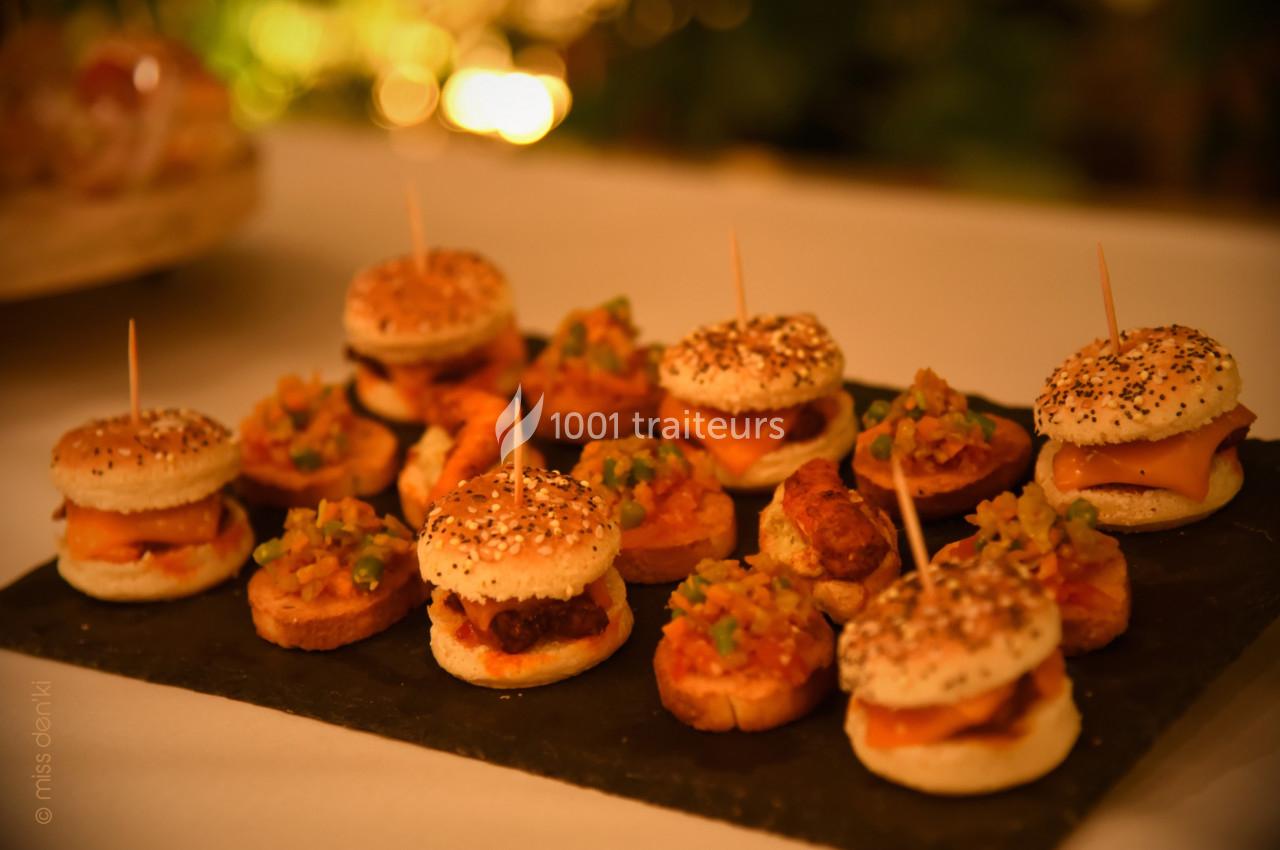 Traiteur Kreyol Kitchen Traiteur Morestel #1 Plateau de mini-burgers et bouchées garnies de légumes, présenté sur une ardoise dans un cadre chaleureux.