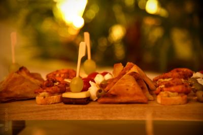 Traiteur Kreyol Kitchen Traiteur Morestel #5 Assortiment de bouchées apéritives variées disposées sur un plateau en bois, avec un arrière-plan flou et lumineux.