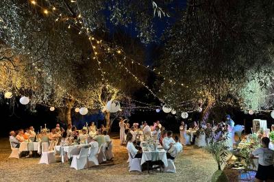 Traiteur Lorette Traiteur Antibes #4 Dîner en plein air sous des guirlandes lumineuses et lanternes, avec des invités assis à des tables décorées.
