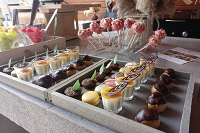 Traiteur L'Atelier de Nicolas Frontignan #2 Plateau de desserts variés comprenant verrines, macarons, choux au chocolat et sucettes décorées sur une table en bois.