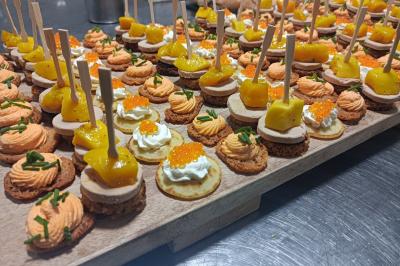Traiteur L'Atelier de Nicolas Frontignan #3 Plateau de canapés variés avec mousse, œufs de poisson, fromage et garnitures colorées sur un plan de travail.
