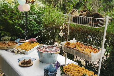 Buffet en plein air avec desserts variés, gâteaux, biscuits et décorations dans un cadre verdoyant.