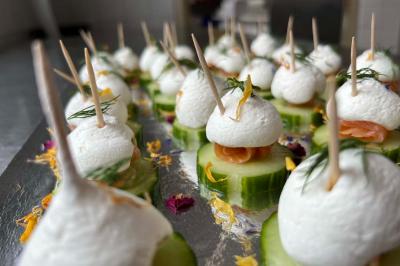 Bouchées apéritives sur rondelles de concombre, garnies de saumon, fromage frais et herbes, fixées par des piques.