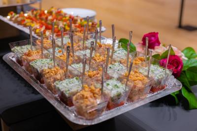 Plateau de verrines variées contenant des préparations colorées, disposées avec des cuillères sur une table.